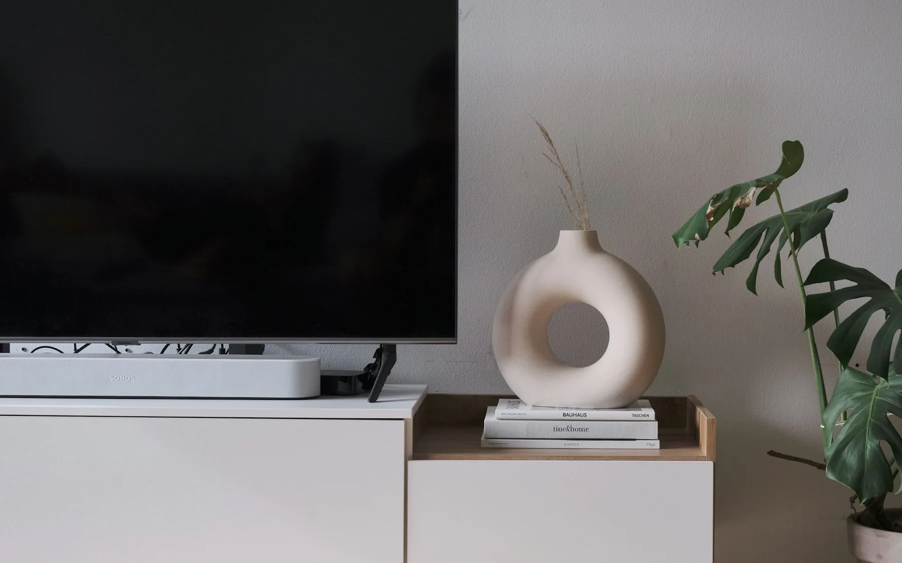 Comodă joasă de living sub televizor, perete de apartament