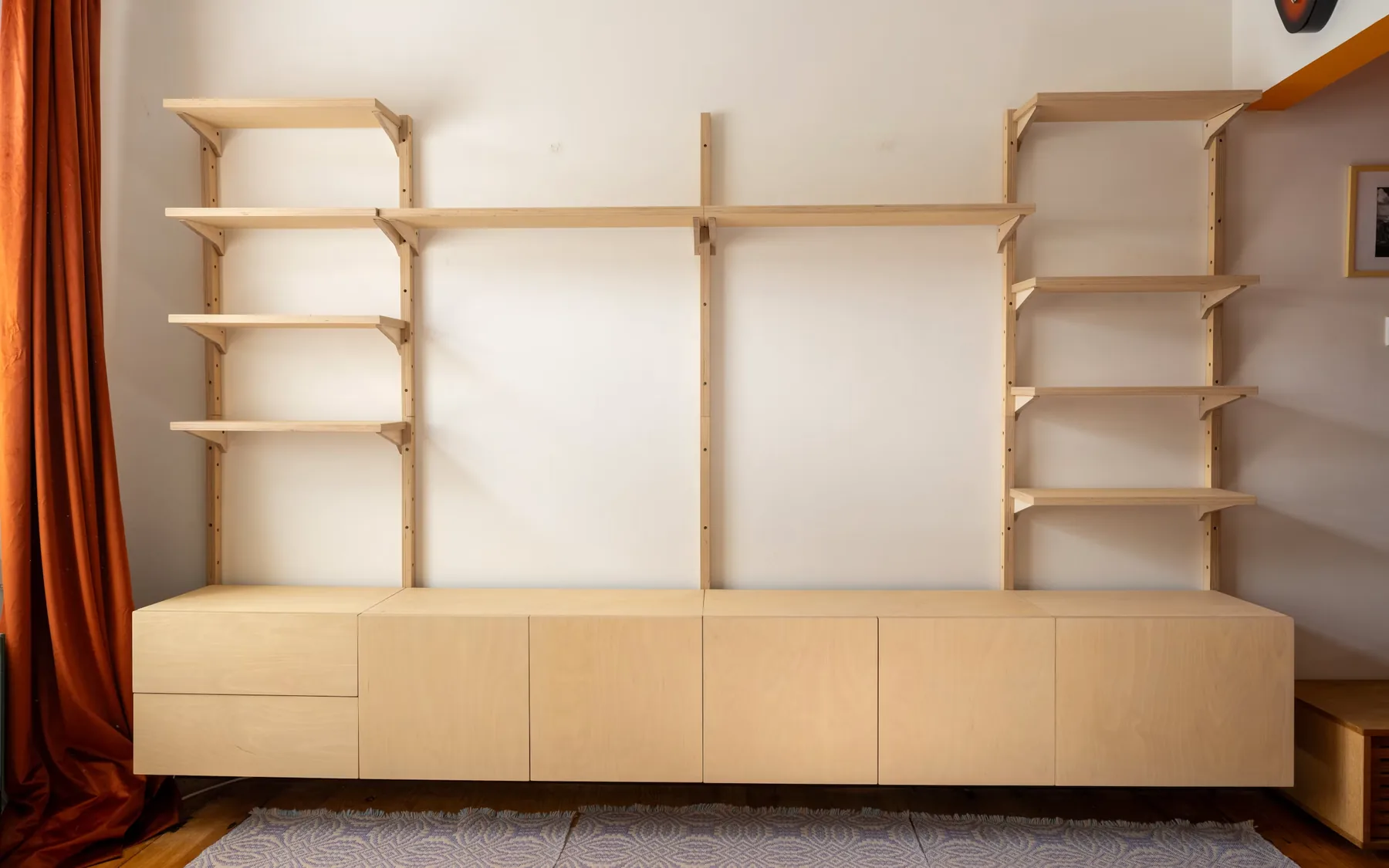Perete de living cu corpuri joase și vitrine, apartament